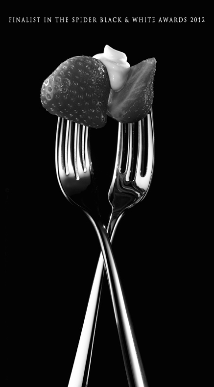 Strawberry shared by two chrome forks-food photography