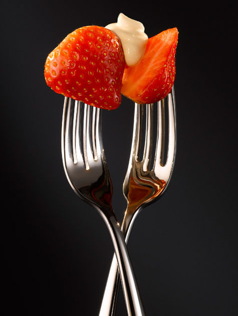 Strawberry shared by two chrome forks-food photography